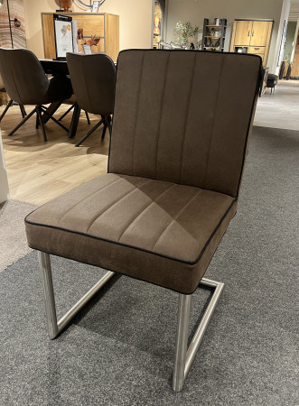Stuhl „Mondo Natur Carpa“ aus Mikrofaser in Creme, Beine aus Edelstahl-Rundrohr auf Teppichboden; Möbel im Hintergrund zu sehen.