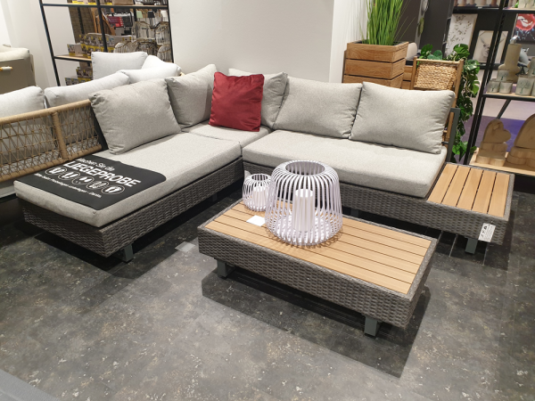 Lounge-Set „Rügen 2“ mit einem roten Kissen und einem Tisch mit Polywood-Tischplatte auf grauem Marmorboden sowie schicken Akzenten.