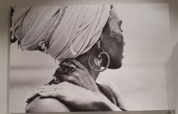 Leinwandbild „Frau mit Turban“, 120 × 80 cm: Schwarz-Weiß-Profilfoto mit Kopftuch, Ohrringen und sandbedeckter Haut.