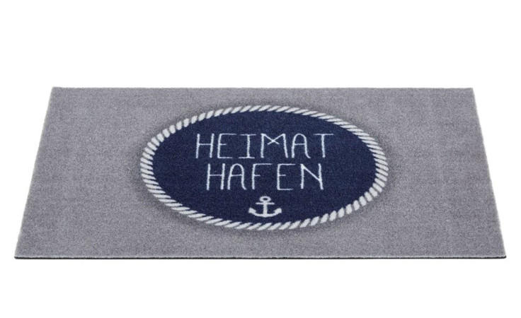 Astra Fußmatte Homelike 40x60cm, graues Polyamid mit marinefarbenem Kreis, Anker, Seilrand & "Heimat Hafen" in Weiß.