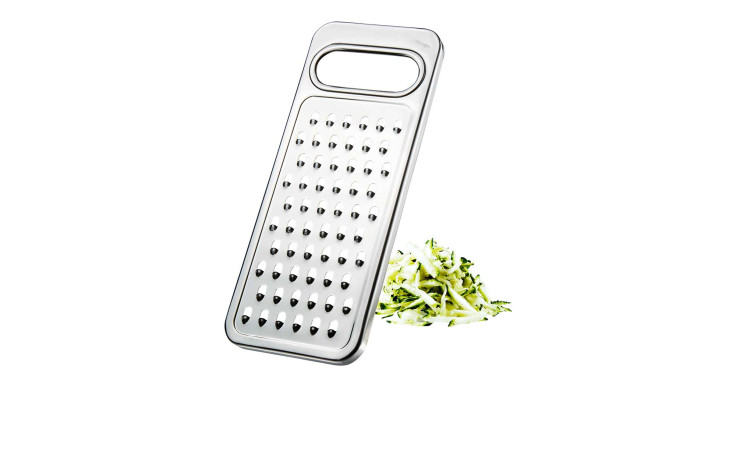 Die GEFU Gemüsereibe Retaro mit Griff steht neben geraspelten Zucchini auf weißem Hintergrund.