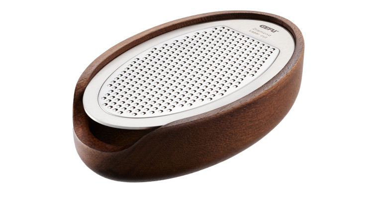 Die GEFU Parmesanreibe Parmezo besteht aus einer ovalen, rostfreien Reibe in einer Schale aus dunklem Akazienholz mit einer Auffangmulde.