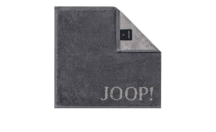 EIN JOOP! Seiftuch Classic 30x30 cm von Joop in Anthrazit, mit einer umgeknickten Ecke, die eine helle Unterseite und ein schwarzes Etikett zeigt.