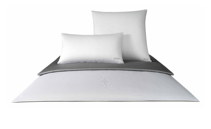 Ein Bett gemacht mit Joop Mako-Satin Bettwäsche JOOP! 135 x 200 cm, weißen Kissen und einer gefalteten grauen Decke darauf.