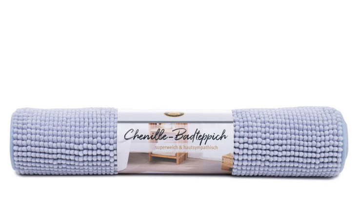 Eine aufgerollte hellviolette Gözze-Badematte mit einem Etikett mit der Aufschrift "Badteppich Chenille 60 x 100 cm" auf Deutsch.