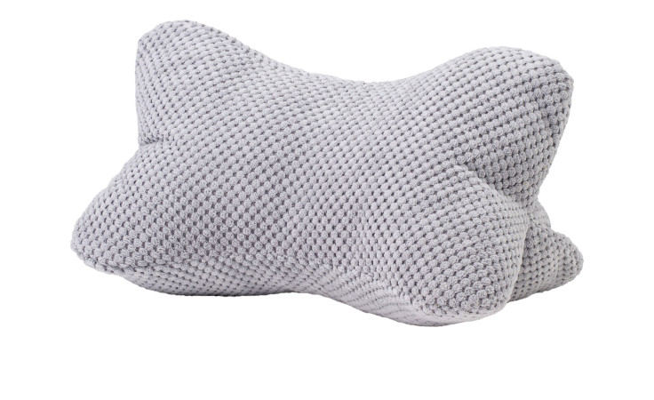 Lesekissen Sven von Ambiente Trendlife, 40x25 cm, in Knochenform aus hellgrauer Kunstfaser auf weißem Grund.