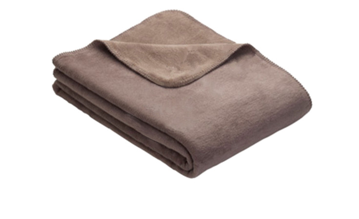 Eine gefaltete Heimdecke Doubleface 150 x 200 cm aus braunem Fleece auf weißem Grund.