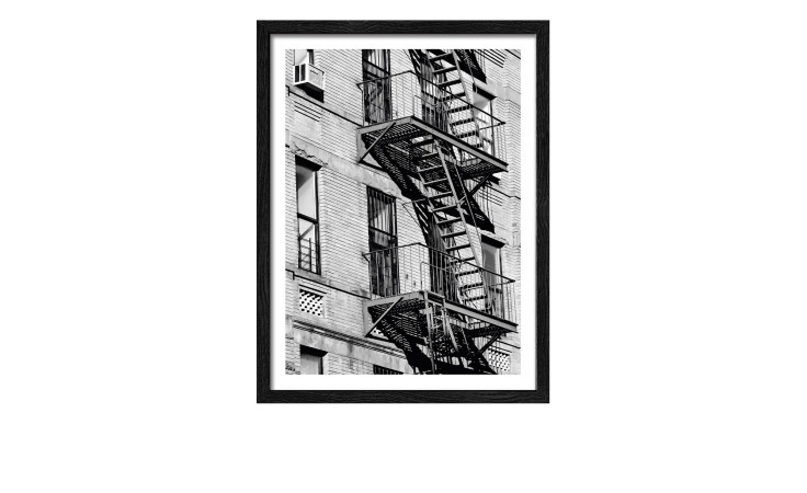 Schwarz-Weiß-Foto eines Backsteingebäudes mit Feuerleiter im Pro-Art Rahmenbild Window View 33 x 43 cm.