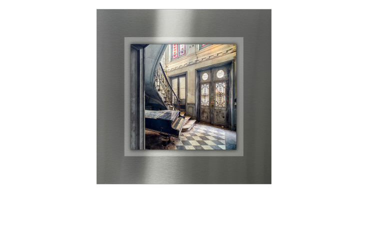 Alubild Lost Lobby 50x50 cm von Pro-Art zeigt ein altes Klavier neben einer Wendeltreppe auf kariertem Boden in einem Vintage-Zimmer.