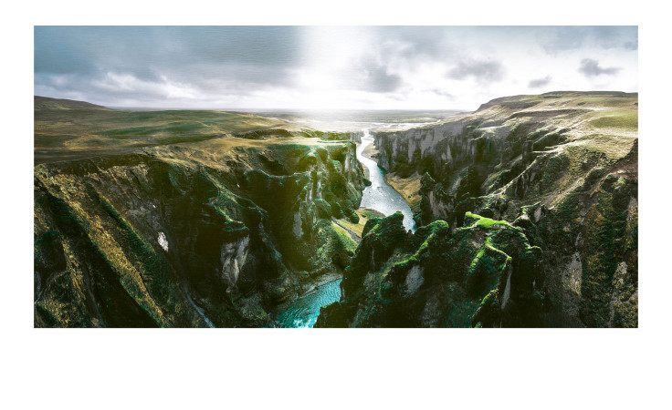 Das Alubild Entrenched River 100 x 200 cm von Pro-Art zeigt bunte Canyon-Felsen und einen sich windenden Fluss unter einem wolkenverhangenen Himmel.