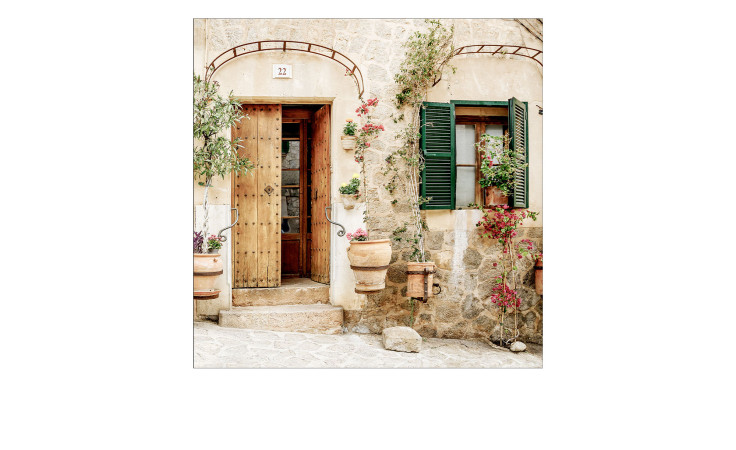 Glasbild Mediterranes Haus 30x30 cm von Pro-Art: rustikales Steinhaus, Holztür und buntes Dekor in der Sonne.