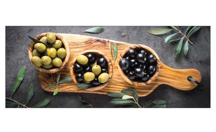 Pro-Art Glasbild Mediterrean Food I 50 x 125 cm zeigt Holzschalen mit Oliven und Olivenzweigen auf einer dunklen Platte.