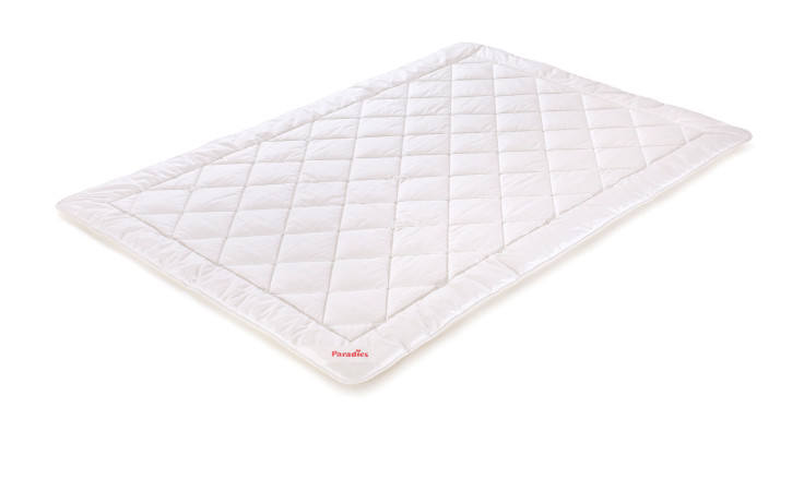 Die Paradies Sommerbettdecke Cool Comfort Bio 135x200 cm ist eine weiße, rautenförmig gesteppte Unterlage auf weißem Hintergrund.