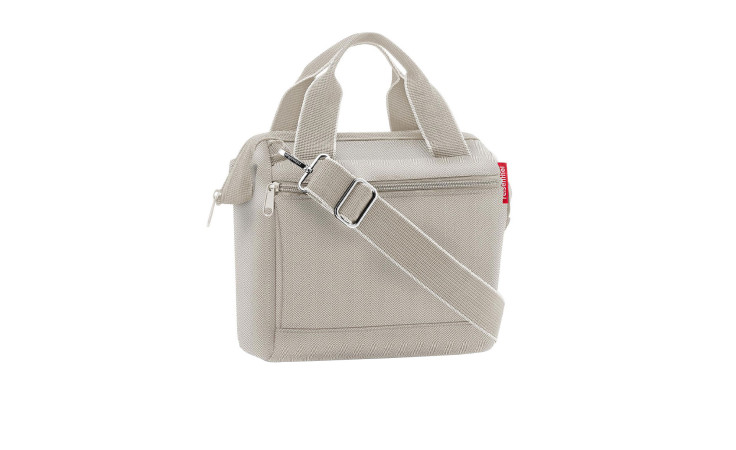 Die Umhängetasche Allrounder Cross von Reisenthel ist eine beigefarbene Umhängetasche aus recyceltem Polyester mit Tragegriffen und Reißverschlusstasche vorne.