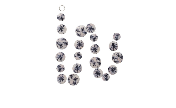 Zwanzig kreisförmige weiße Perlen mit blauen Blumenmustern und einem Metallring aus Capiz-Girlande Palma L.180 cm auf weißem Hintergrund.