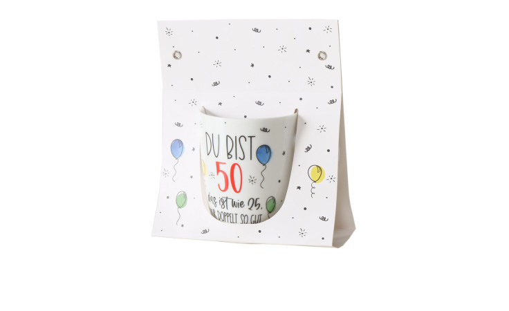 Ein Becher 330 ml aus Keramik mit Aufdruck "Du bist 50", Luftballons und Konfetti auf weißem Hintergrund.