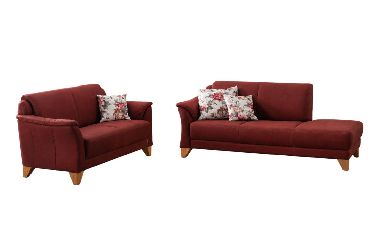 Zwei kastanienbraune MONDO Quadra-Sofas mit Boxspring-Polsterung und Kissen mit Blumenmuster sorgen für Komfort vor einem weißen Hintergrund.