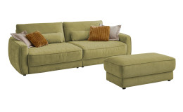 Komfort-Big Sofa planoform Cochem in der Farbe Hellgrün mit mehreren Kissen, zwei davon sind braun, und der passende Hocker dazu