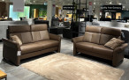 Zwei Mondo Comfort Evado-Sofas stehen sich auf einem beigen Teppich gegenüber, dazwischen liegen Zierkissen.