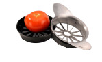 Eine Tomate liegt im silberfarbenen GEFU Tomaten-/Apfelteiler Pomo mit scharfen Klingen und einem runden Design.