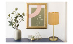 Fischer-Honsel Tischleuchte Aura 34 cm, Vase mit Grünzeug, Samtdekor und goldgerahmter abstrakter Kunst auf Blau.