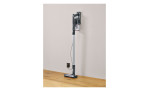 Der Severin SEVERIN 2-in-1 Hand- und Stielsauger lädt sich in seiner Wandhalterung auf einem Holzboden auf.