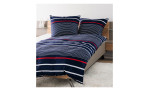 Ein Bett mit Mako-Satin-Bettwäsche J.D. 135 x 200 cm in navy, weiß, rot gestreift plus zwei passende Kissen.
