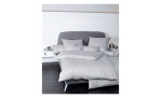 Mako-Satin Kissenbezug Colors, in der Größe 40 x 80 cm und in der Farbausführung silber, auf einem Bett bezogen mit der passenden Bettwäsche und weiteren Kissen