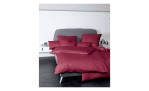 Mako-Satin Kissenbezug Colorsin der Größe 40 x 40 cm und in der Farbausführung rot, auf einem bett bezogen mit der passenden Bettwäsche und weiteren Kissen