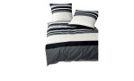 Ein Bett mit zwei Kissen und Mako-Satin-Bettwäsche J.D. 135 x 200 cm in schwarz, weiß und grau quer gestreift.
