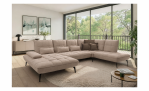 Modernes Wohnzimmer mit einem Vito Ticona Plus-Ecksofa, einem runden Teppich, einem Couchtisch und großen Fenstern.