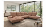 Modernes Wohnzimmer mit der Vito Komfort-Wohnlandschaft „vito Ticona Plus“, einem runden Teppich, einem Couchtisch und Blick auf Bäume.