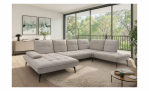Modernes Wohnzimmer mit der Vito Komfort-Wohnlandschaft Ticona Plus, einem runden Teppich, einem Couchtisch und großen Fenstern.
