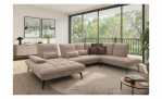 Modernes Wohnzimmer mit der Komfort-Wohnlandschaft „vito Ticona Plus“ von Vito, einem runden Teppich, einem Couchtisch und großen Fenstern.