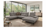 Graues L-förmiges Vito Ticona Plus-Modulsofa mit kapuptonen Kissen und dunklen Metallbeinen in einem Wohnzimmer.