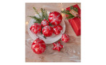 Christbaumkugel 6 cm aus Glas, rot-silber mit weißen Designs, Tanne und Geschenk auf dem Teller.