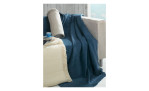 Ein champagnerbeiges Sofa mit einer blauen Decke und einer cremefarbenen Casa Nova Fransenplaid-Decke 130x170 cm auf dem Boden.