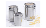 Drei silberne Casa Nova Vorratsdose 10 x 7 cm mit klaren Deckeln enthalten Nudeln und Körner auf einer weißen Oberfläche.
