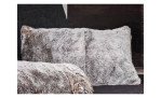 Das Mondo Fellimitatkissen Fluffy MONDO 40 x 60 cm in grau ruht vor einem dunklen Hintergrund, mit einer passenden Decke davor.
