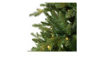 Nahaufnahme der grünen Kunststoff-Kiefernzweige von Tannenbaum Allison II 210 cm mit weißer Lichterkette auf weißem Hintergrund.