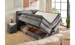 Boxspringbett Quinto Mix in der Farbe Grau in einem Zimmer mit geöffnetem Bettkasten
