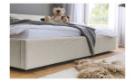Familienbett Calau – ein flaches Bett mit einem cremefarbenen, gerippten Rahmen und einem Teddybären auf weißer Bettwäsche.