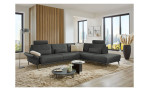 Komfort-Ecksofa plano|FORM Formello, in der Farbausführung Anthrazit, in einem Raum stehend mit der klappbaren Armlehne und mit Kissen und Kopfstütze