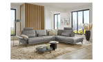 Komfort-Ecksofa plano|FORM Formello, in der Farbausführung Grau, in einem Raum stehend mit der klappbaren Armlehne und mit Kissen und Kopfstütze