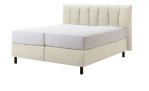 Basis-Boxspringbett Tokyo in einem Beigen Bezug aus Kunstleder. Schräge Seitenansicht
