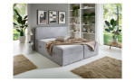 Modernes Schlafzimmer mit dem Boxbett „Action“, beigen Decken und Regalen, die die Tiefe und Breite des Raums betonen.