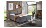 Boxspringbett Kansas in der Farbe Grau mit einem weißen Topper, 2 Kissen und einer Decke, Milieubild