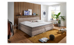 Boxspringbett Family, in der Farbausführung Taupe, in einem Raum stehend mit Deko