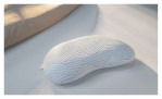 Schlafkissen Discovery SmartCool Curve S in einem weißen Bezug. Auf einem dekorierten Hintergrund