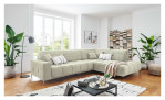 Wohnlandschaft Luan in Creme mit Cord-Optik, inszeniert auf gemustertem Teppich mit schwarzem Couchtisch und Stehlampe.